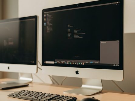 접힌 종이 지도와 나침반, 게임패드가 놓인 나무 책상 위